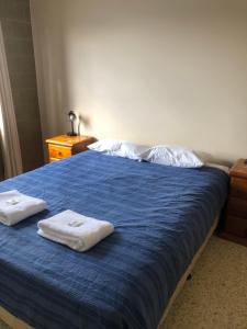 Un dormitorio con una cama azul con toallas. en Unit 5 Pattison, en Emu Park