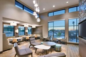 una sala de espera con mesas, sillas y ventanas en Residence Inn by Marriott Phoenix West/Avondale, en Avondale