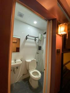 a bathroom with a toilet and a sink at Harimariz Dormitory Official in Dumaguete
