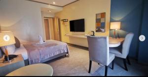 um quarto de hotel com uma cama, uma mesa e uma secretária em Yes Hotel San Ildefonso Bulacan em Buliran