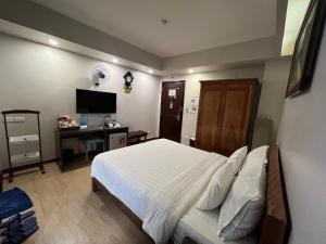 a bedroom with a bed and a desk and a television at A25 Hotel - 88 Nguyễn Khuyến in Hanoi