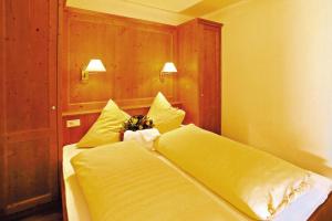 um quarto com uma cama com lençóis e almofadas amarelas em Apartment in Achenkirch with a garden em Achensee
