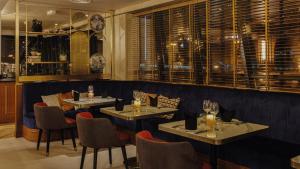 un restaurante con 2 mesas, sillas y ventanas en Millennium Place Dubai Marina en Dubái