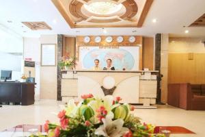 two people at a podium in a lobby with flowers at Boss Place 306-308 Nguyen Thien Thuat Street, District 3 - by Bay Luxury Hotel in Ho Chi Minh City