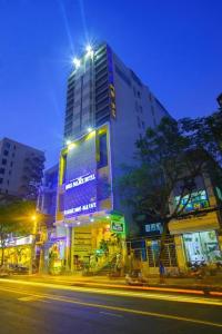 a tall building with lights on it on a city street at Boss Place 306-308 Nguyen Thien Thuat Street, District 3 - by Bay Luxury Hotel in Ho Chi Minh City