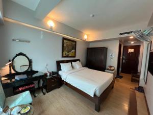 a bedroom with a bed and a desk and a mirror at A25 Hotel - 88 Nguyễn Khuyến in Hanoi