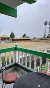 una silla sentada en un balcón con campo de béisbol en HOTEL GREEN VIEW BOMDILA,Bomdila en Bomdila