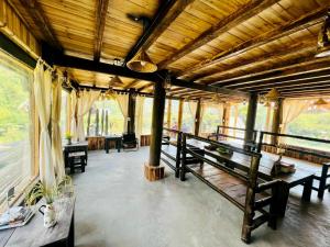uma sala com bancos e mesas num edifício em Lao Chải riverside stay&coffee em Sapa