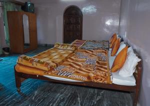 a bed in a room with a bedspread on it at Himalaya Mount View Resort Uttarakhand in Kausani