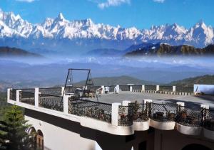 a balcony with a view of the mountains at Himalaya Mount View Resort Uttarakhand in Kausani