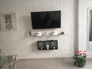 biała ceglana ściana z telewizorem z płaskim ekranem w obiekcie Casa Stefire 1 Pachino centro w mieście Pachino
