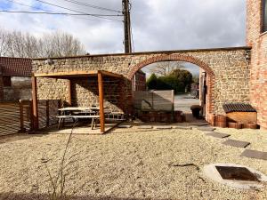 einen Eingang zu einem Backsteingebäude mit einem Picknicktisch in der Unterkunft Résidence du moulin 2-B-1 in Boussu