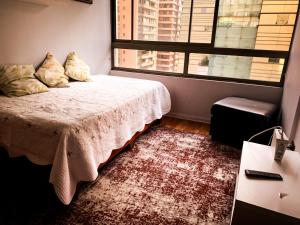 a bedroom with a bed and a large window at Depto Metro Plaza de Armas (1 dormitorio 1 baño) in Santiago