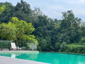 a chair sitting next to a swimming pool at Taiping City View Condo near Lake Garden/ Netflix in Taiping