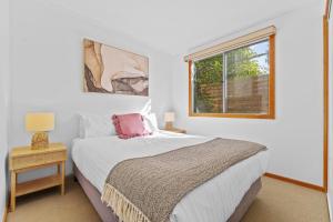 a white bedroom with a bed and a window at BIG4 Tasman Holiday Parks - Bright in Bright
