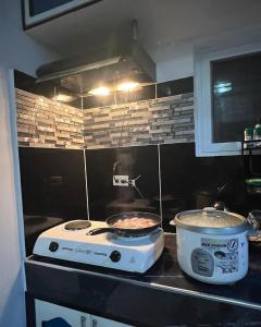 uma cozinha com um fogão e uma panela de comida em Charlotte's Vacation Home Busuanga Palawan 