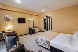 a hotel room with a bed and a television at Days Hotel By Wyndham Baku in Baku