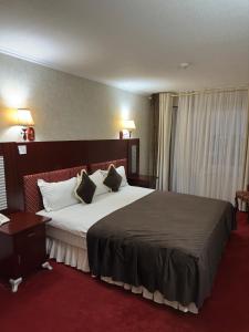 um quarto de hotel com uma cama grande com almofadas brancas em BUKHARA GRAND HOTEL em Bukhara
