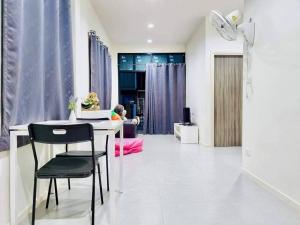 a living room with a table and chairs and a child at บ้านคุณพระ แอท โกเตง in Suratthani