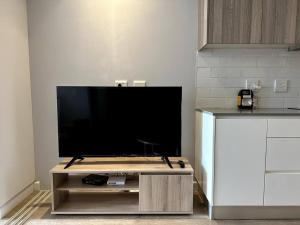 a flat screen tv on a table in a kitchen at City view studio apartment CBD in Cape Town
