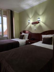 um quarto de hotel com duas camas e uma janela em BUKHARA GRAND HOTEL em Bukhara