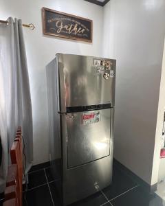 um frigorífico numa cozinha com uma placa na parede em Charlotte's Vacation Home Busuanga Palawan 