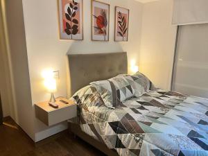 a bedroom with a bed and a table with a lamp at Moderno Apartamento en el Centro in Bogotá