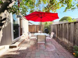 uma mesa e cadeiras com um guarda-sol vermelho num pátio em 839-Sunnyvale Great location 2Br/2Bth unit/Kingbed em Sunnyvale