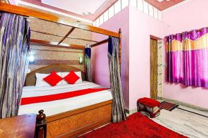 a bedroom with a bed with red pillows at Super OYO Flagship 72253 Jai Maa Palace Hotel in Jaipur