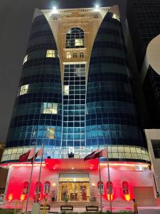 a building with red lights in front of it at Musherib Hotel in Doha