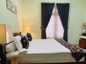 Un dormitorio con una cama grande y una ventana en Just 11 Boutique Syariah Mitra RedDoorz near UGM Yogyakarta, en Kejayan