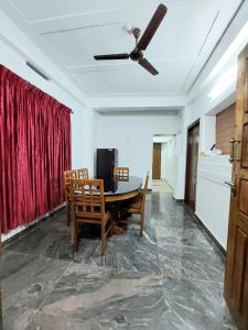 d'une salle à manger avec une table et un ventilateur de plafond. dans l'établissement Shalom Homestay Thekkady, à Thekkady