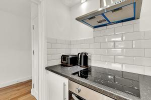 a kitchen with a stove and a counter top at Contemporary Oasis in Paddington III in London