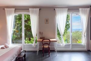 - une chambre avec un bureau, un lit et des fenêtres dans l'établissement Villa Mont des Oiseaux Hyères Piscine Vue Panoramique Mer Grande Terrasse, à Hyères