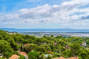 - une vue aérienne sur une ville arborée et l'océan dans l'établissement Villa Mont des Oiseaux Hyères Piscine Vue Panoramique Mer Grande Terrasse, à Hyères