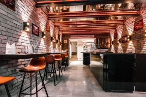 a bar with stools in a room with a brick wall at Cozy & 3 minutes from main square - J in Zagreb