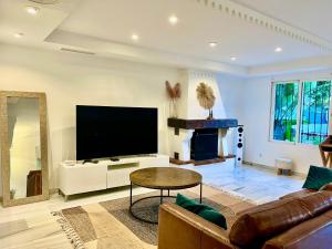 uma sala de estar com uma televisão, um sofá e uma mesa em Marbella Trocadero Beach & Pool em Marbella