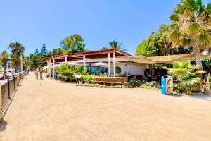 a building on a sandy beach with palm trees at Marbella Trocadero Beach & Pool in Marbella