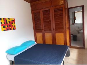 a bedroom with a blue bed and a bathroom at Hotel Habitat Hospedaje in Bogotá