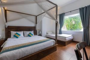 a bedroom with a canopy bed and a window at Suite Home Boutique Hotel in Phnom Penh