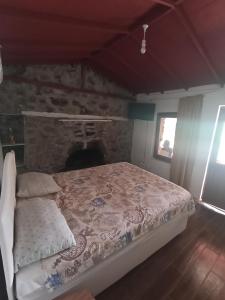 a bedroom with a bed with a stone fireplace at Su camping in Dağpınar