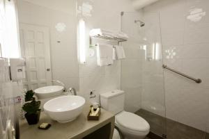 ein weißes Bad mit einem WC und einem Waschbecken in der Unterkunft Tierra Viva Cusco Saphi Hotel in Cusco