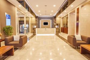 a lobby with chairs and a reception desk in a building at Park Dedeman Bostanci Hotel in Istanbul