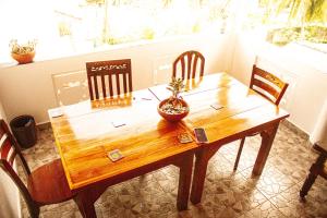 uma mesa de madeira com cadeiras e um vaso de plantas sobre ela em Golden Town Hostel em Tangalle