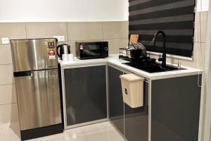 a kitchen with a stainless steel refrigerator and a microwave at Biubiu Home in Melaka