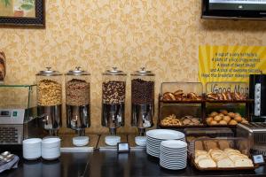 um balcão com vários recipientes de alimentos e produtos de pastelaria em Days Hotel By Wyndham Baku em Baku