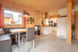 eine Küche und ein Esszimmer mit einem Tisch und einem Kühlschrank in der Unterkunft Almdorf Hohentauern by ALPS RESORTS in Hohentauern