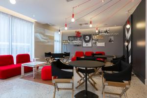 un restaurante con mesas y sillas rojas en una habitación en ibis Styles Paris Mairie de Montreuil en Montreuil