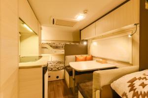 Una pequeña habitación con una cama y un lavabo. en 長崎鼻ビーチリゾート, en Kakaji
