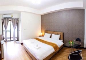 1 dormitorio con 1 cama grande en una habitación en ตาฟ้าเรสซิเดนซ์ (Tafah Residence) en Sakon Nakhon
